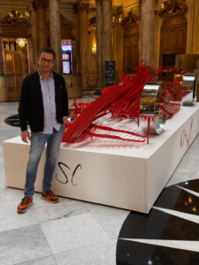 Steve Chaudanson standing beside the monumental F'ONE sculpture at the Casino de Monte-Carlo, Monaco.