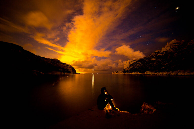 Fine art nature photography of a campfire surrounded by wilderness, captured by French photographer Laurent Leoncini.